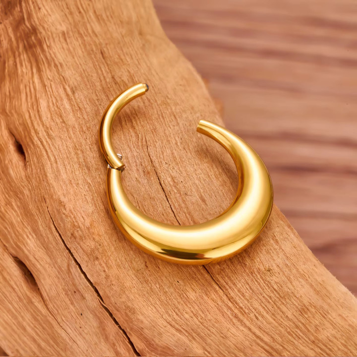 Tytanowy piercing septum, kolczyk koloru złotego, prezentacja otwartego.